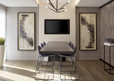 A modern dining room with a rectangular table, six chairs, abstract art on the walls, a black TV, and a geometric light fixture overhead.